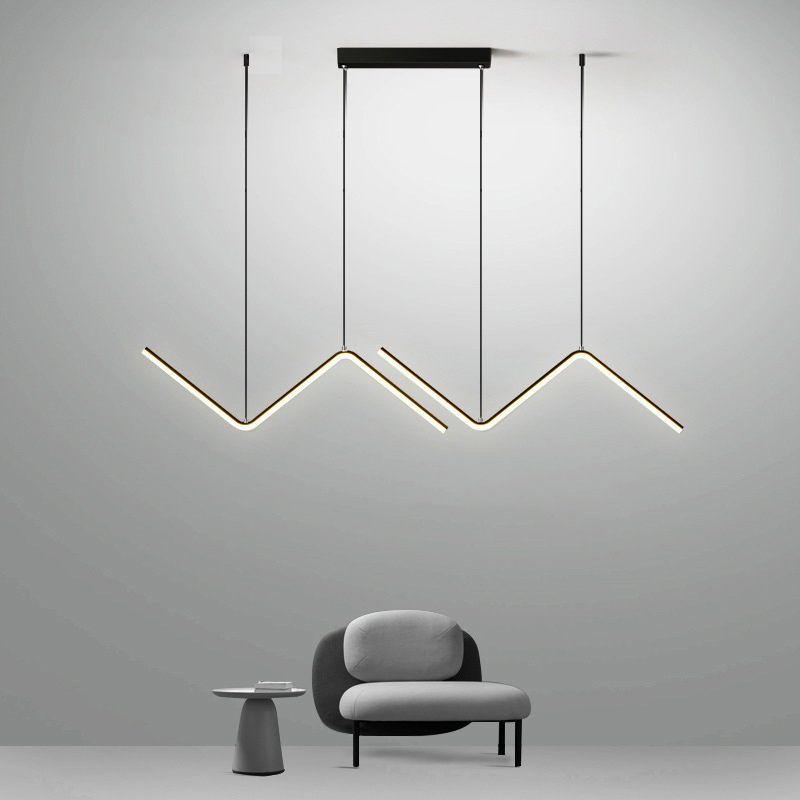 Lustre pendente moderno em LED com design tubular em ziguezague dourado em sala minimalista cinza com poltrona e mesa lateral