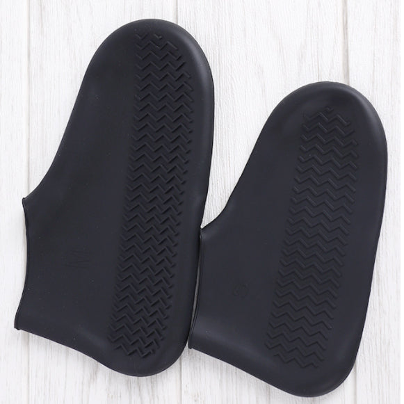 Par de luvas pretas de silicone antiderrapante sobre piso claro