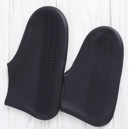 Par de luvas pretas de silicone antiderrapante sobre piso claro