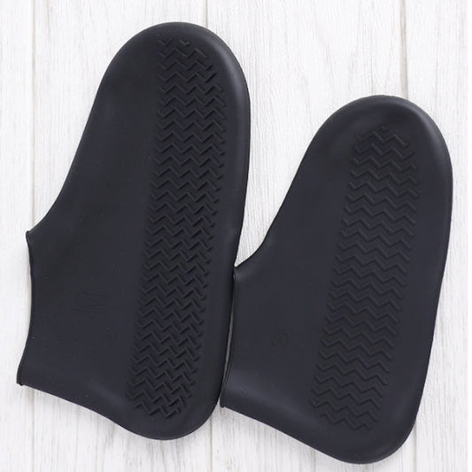 Par de luvas pretas de silicone antiderrapante sobre piso claro