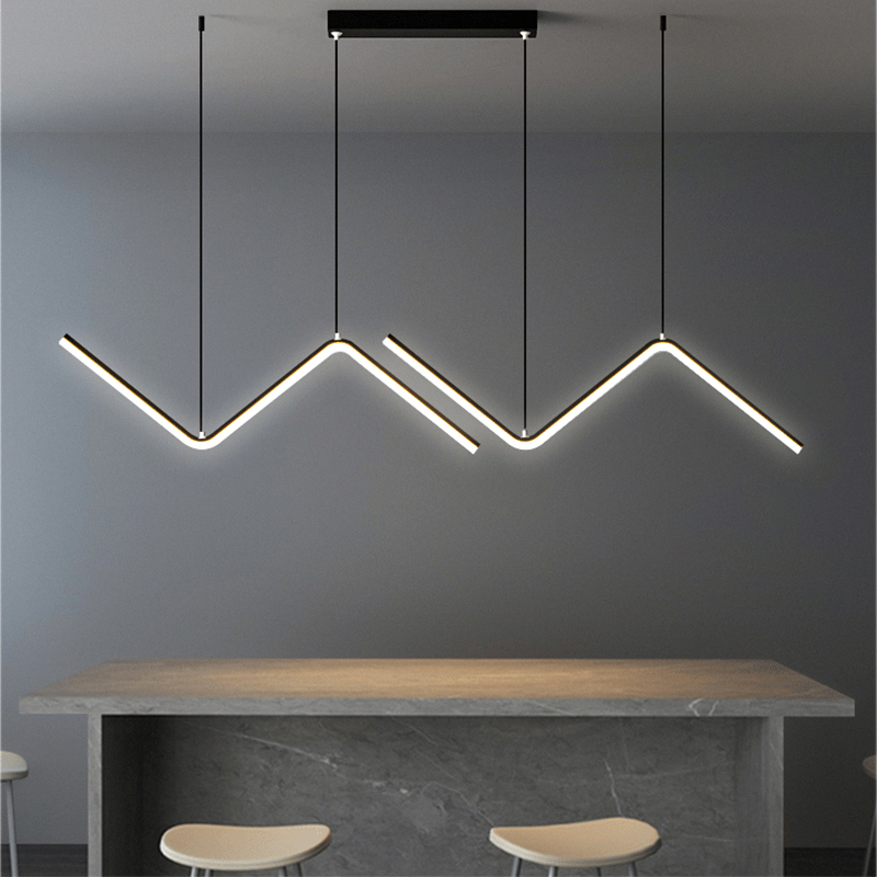 Luminária pendente LED moderna em formato zig-zag acima de bancada de pedra com cadeiras minimalistas