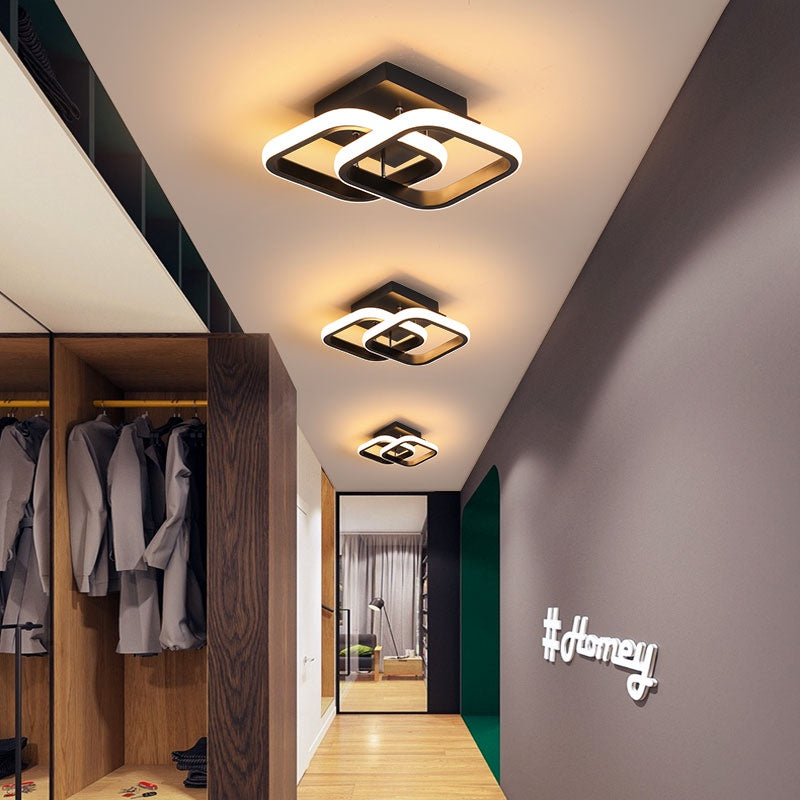 Corredor moderno com iluminação de teto em formas geométricas, armário aberto e parede cinza com hashtag #homey
