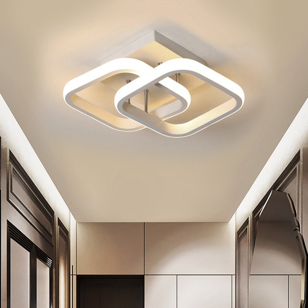 Luminária de teto moderna quadrada branca com design entrelaçado em corredor com paredes claras