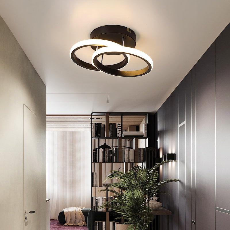 Luminária de teto moderna com anéis iluminados em sala minimalista com planta e estante de livros