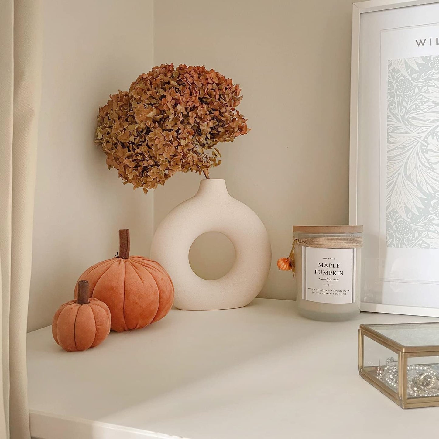 Decoração outonal com vasos de cerâmica, flores secas, abóboras decorativas de veludo e vela maple pumpkin