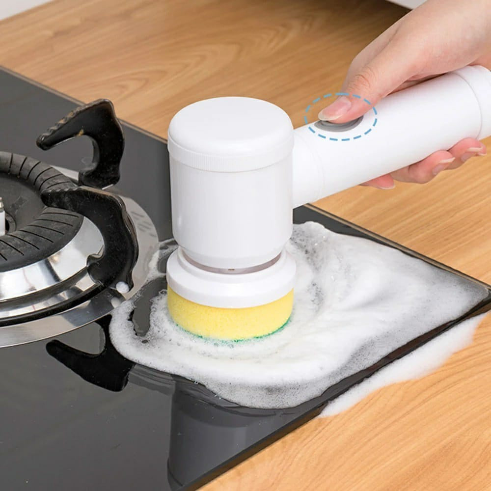 Escova elétrica branca com esponja amarela limpando fogão de vidro preto com espuma de sabão