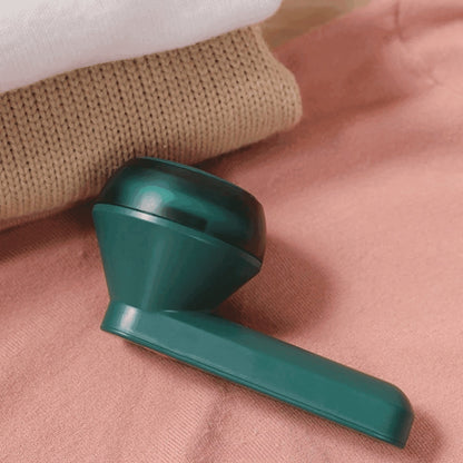 Fone de ouvido sem fio verde sobre tecido rosa e suéter bege de malha