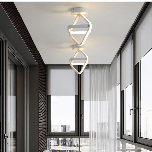 Luminárias LED modernas brancas penduradas no teto de ambiente interno com janelas amplas e cortinas brancas