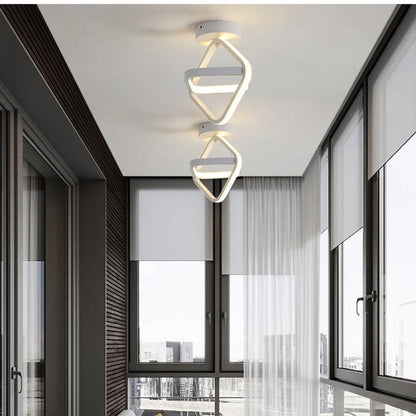 Luminárias LED modernas brancas penduradas no teto de ambiente interno com janelas amplas e cortinas brancas