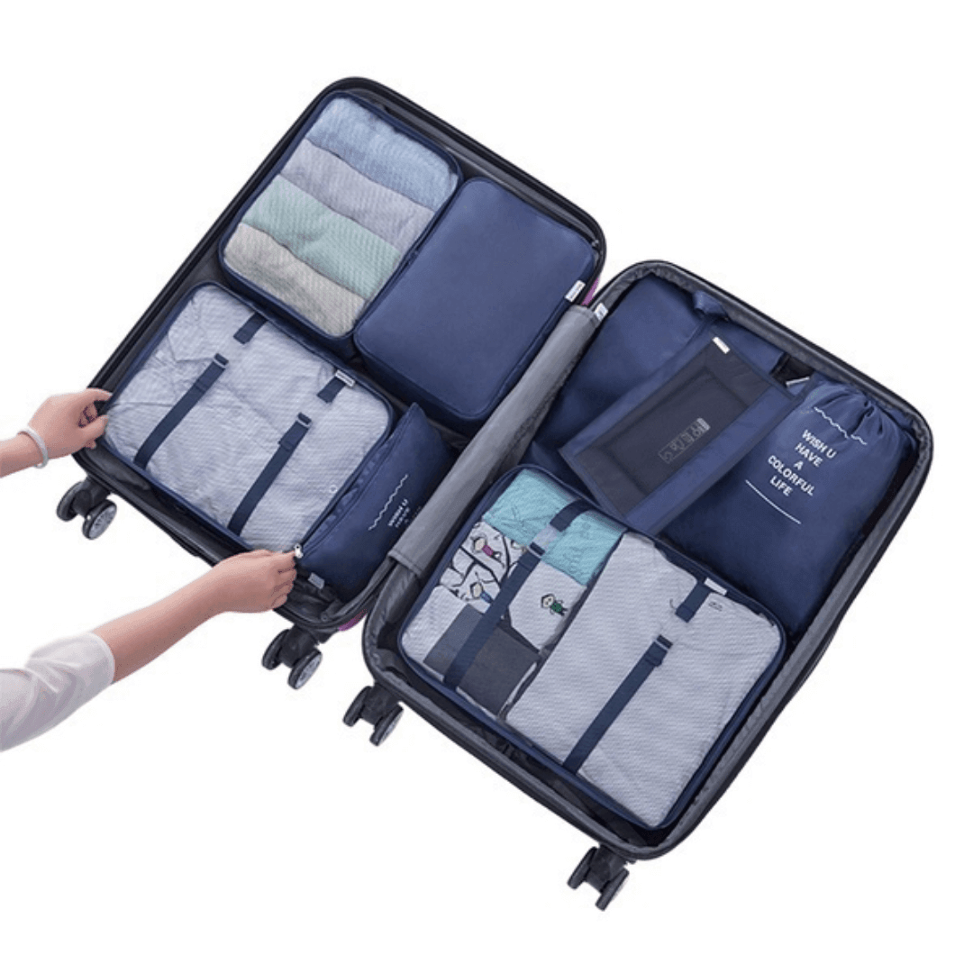 Mala de viagem preta organizada com cubos de bagagem azul marinho e roupas dobradas