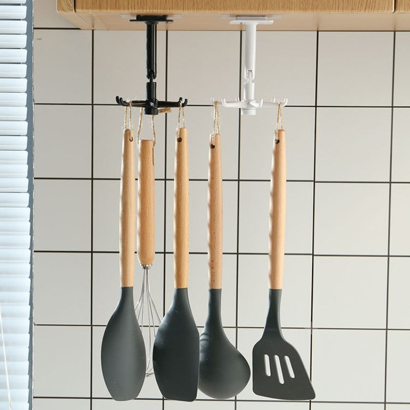 Utensílios de cozinha com cabo de madeira pendurados em suporte de teto preto e branco, parede com azulejos brancos.