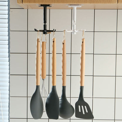 Utensílios de cozinha com cabo de madeira pendurados em suporte de teto preto e branco, parede com azulejos brancos.