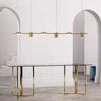 Mesa de vidro com base dourada e lustre pendente minimalista dourado em sala branca com arco