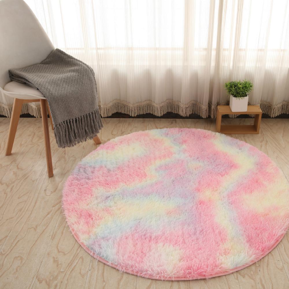Tapete redondo peludo multicolor pastel em sala com cadeira branca e planta decorativa