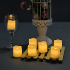 Velas LED amarelas sobre suporte de madeira com taça e vaso branco decorativo com flores