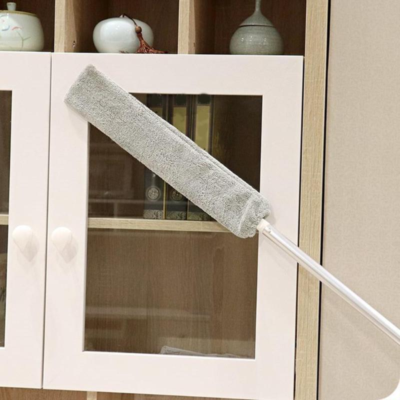 Pano de microfibra cinza para limpeza com cabo branco em armário de madeira com portas de vidro