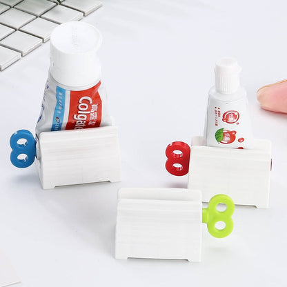 Suportes brancos para espremer tubos de pasta de dente com chaves coloridas em azul, vermelho e verde