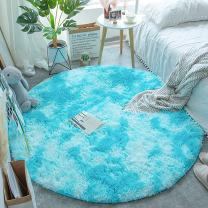 Tapete redondo felpudo azul claro no quarto ao lado da cama branca com manta cinza