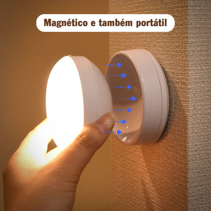Luminária magnética portátil sendo removida da base fixada na parede texturizada