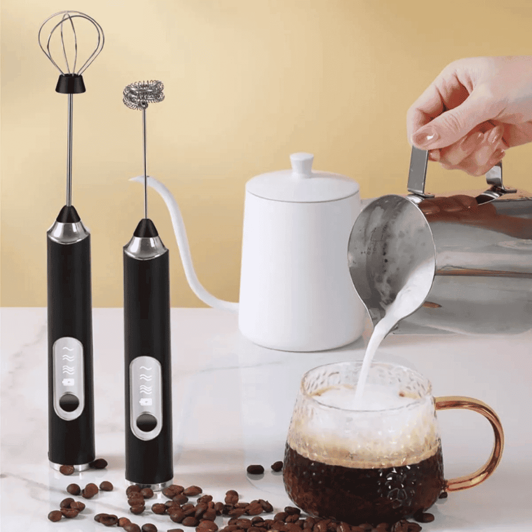 Mixer elétrico recarregável com dois batedores ao lado de jarra branca e café com leite espumado