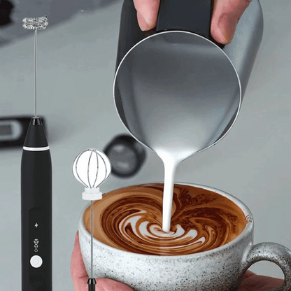 Mixer elétrico recarregável preto para café com batedor em formato de balão, leite sendo despejado em cappuccino