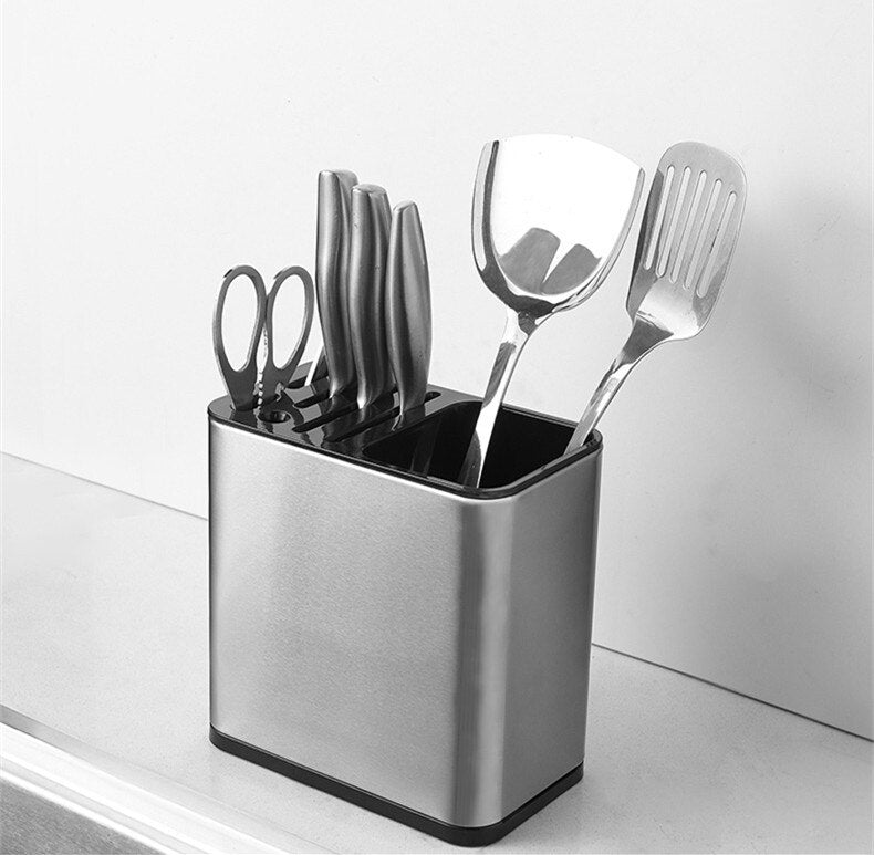 Suporte metálico com facas, tesoura e utensílios de cozinha em bancada branca