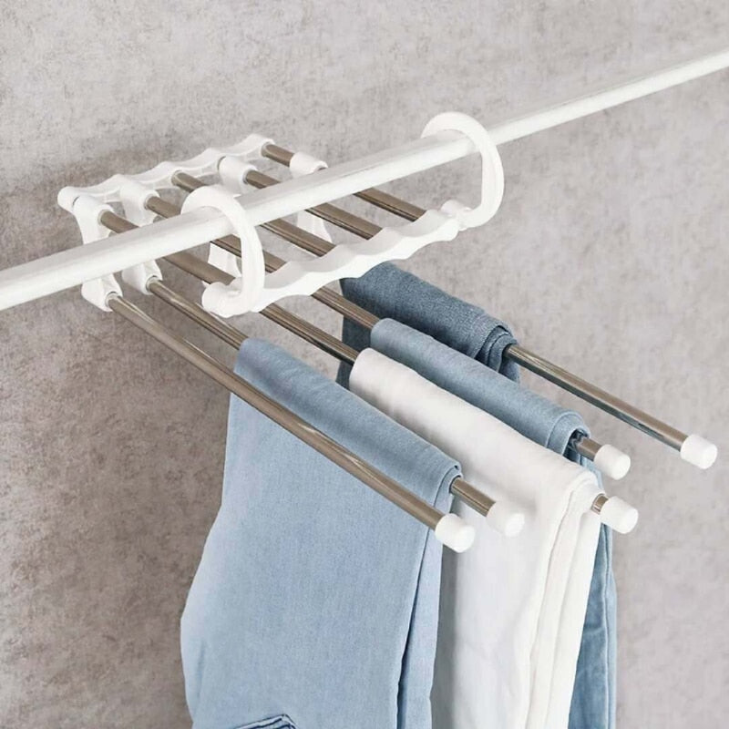 Organizador de calças ajustável em metal e plástico branco, pendurado com várias calças dobradas