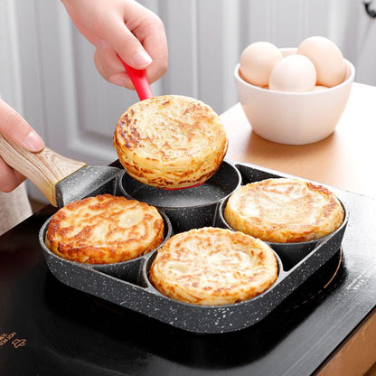 Bolos dourados sendo preparados em frigideira antiaderente de 4 cavidades com alça de madeira em cooktop