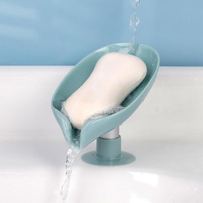 Porta sabonete azul com sabonete branco e água escorrendo para pia branca