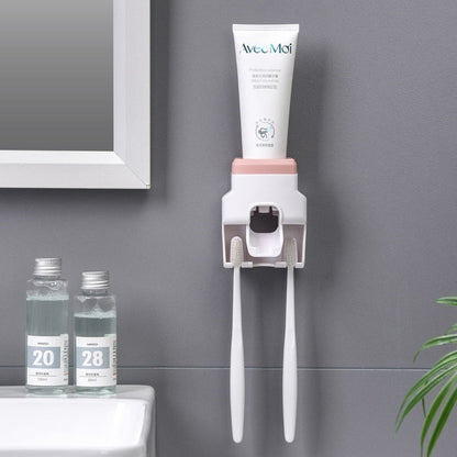 Dispenser automático de creme dental com escovas brancas penduradas em parede cinza