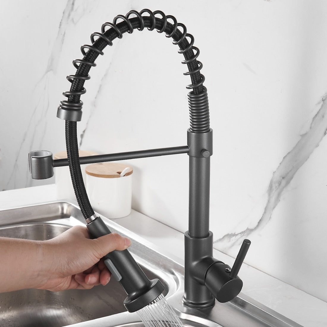 Torneira de cozinha moderna preta com mangueira flexível e jato de água em pia de inox