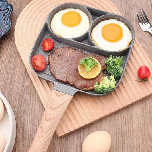 Frigideira de seção dupla com dois ovos fritos, bife com fatia de limão, tomate cereja e brócolis, sobre tábua de madeira