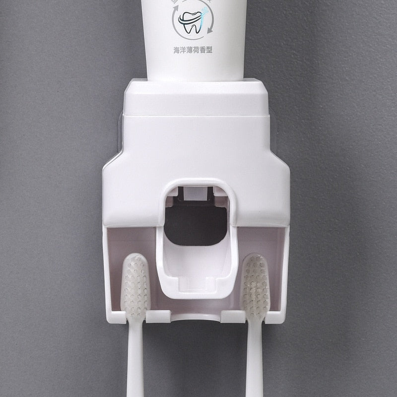 Dispenser branco de pasta de dente montado na parede com duas escovas de dente brancas