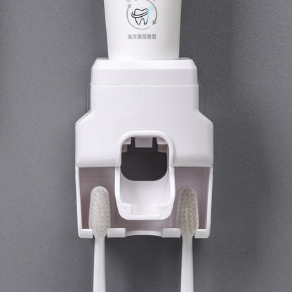 Dispenser branco de pasta de dente montado na parede com duas escovas de dente brancas