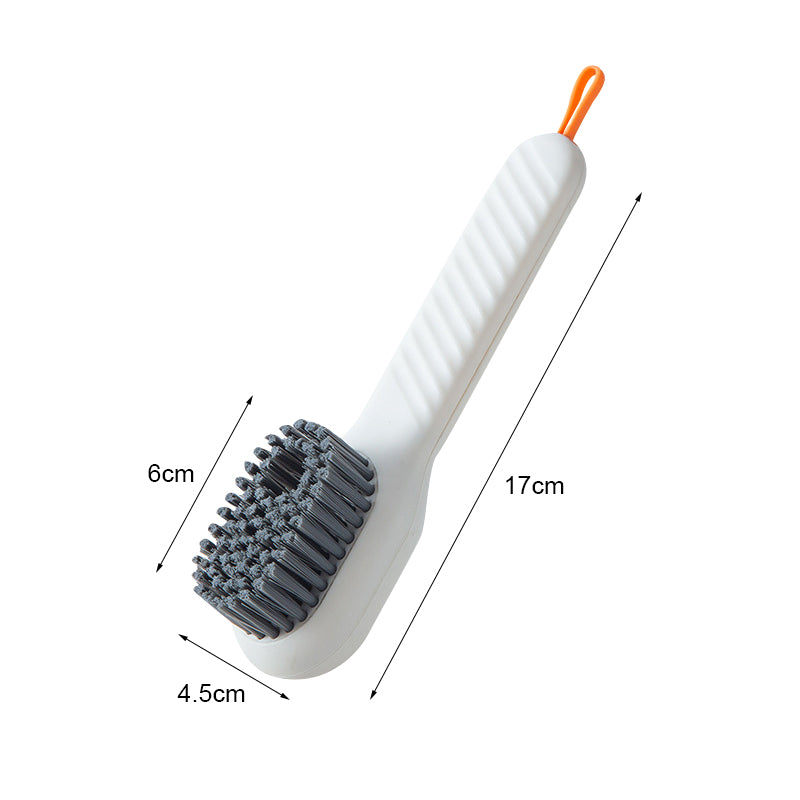 Escova de limpeza branca com cerdas cinzas em formato circular e cabo ergonômico com alça laranja, medidas 17x6x4,5cm