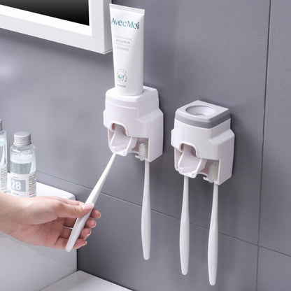 Dispenser de pasta de dente branco montado na parede com escovas de dente penduradas e tubo de creme dental