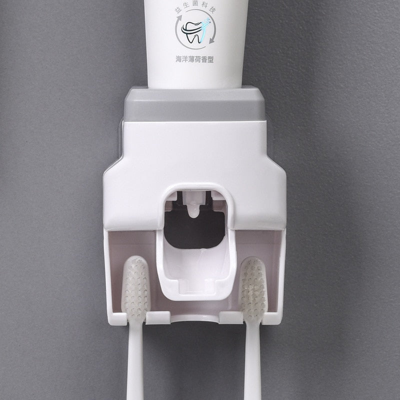 Dispenser automático branco para creme dental com suporte para duas escovas de dentes brancas em fundo cinza