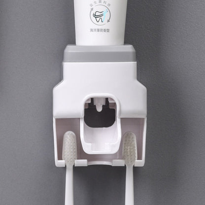 Dispenser automático branco para creme dental com suporte para duas escovas de dentes brancas em fundo cinza