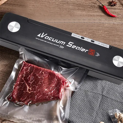Seladora a vácuo preta embalando pedaço de carne crua em superfície de madeira