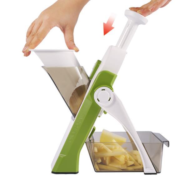 Mandoline cortador de legumes verde e branco com recipiente coletor cheio de batatas cortadas
