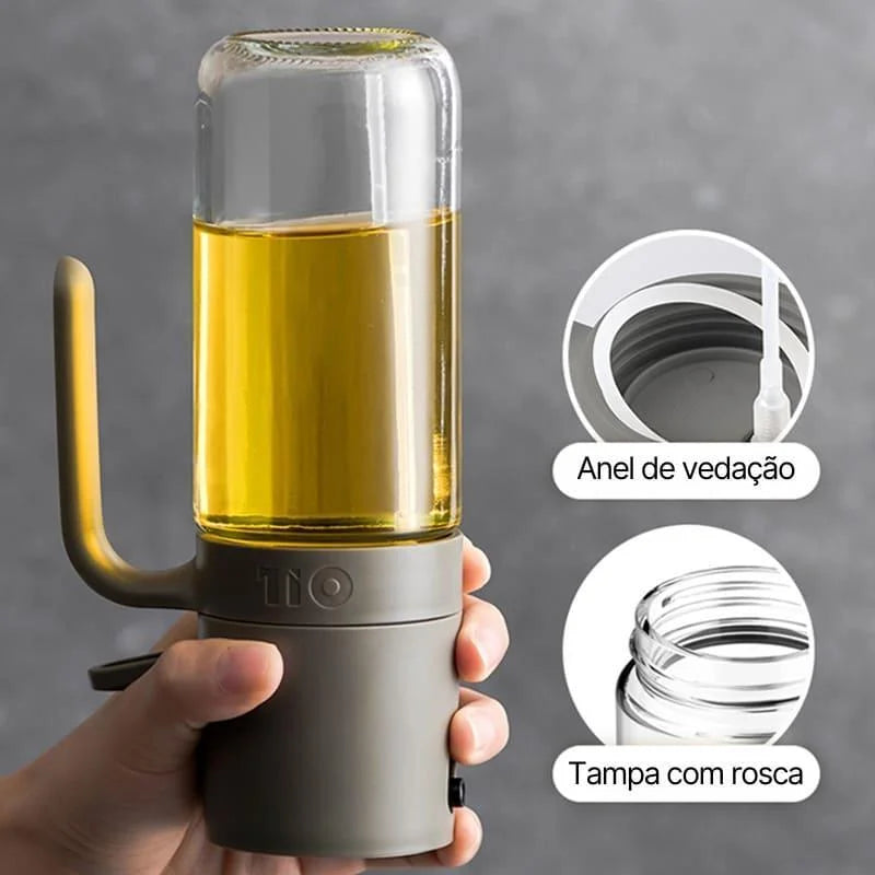Borrifador de azeite elegante com corpo cinza e recipiente de vidro cheio de azeite, detalhes de anel de vedação e tampa com rosca