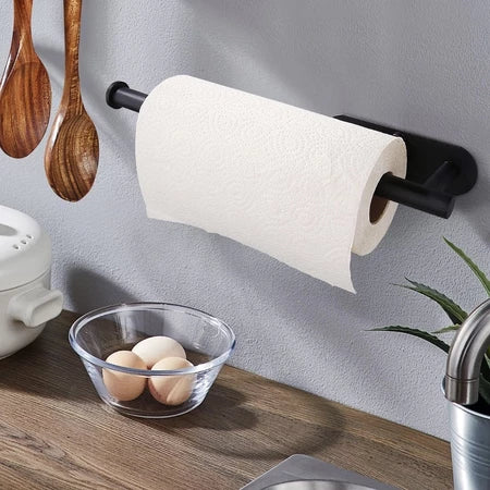 Suporte preto moderno para papel toalha na parede da cozinha com utensílios de madeira e ovos em tigela de vidro