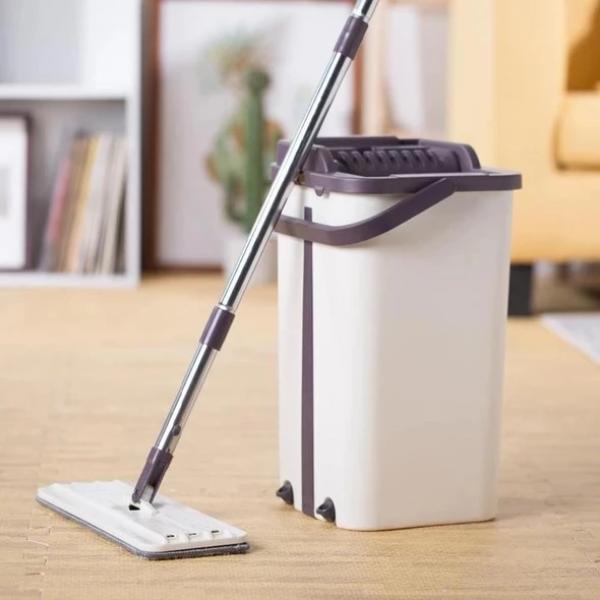 Balde de limpeza branco com rodo de metal e base plana num chão claro em sala moderna