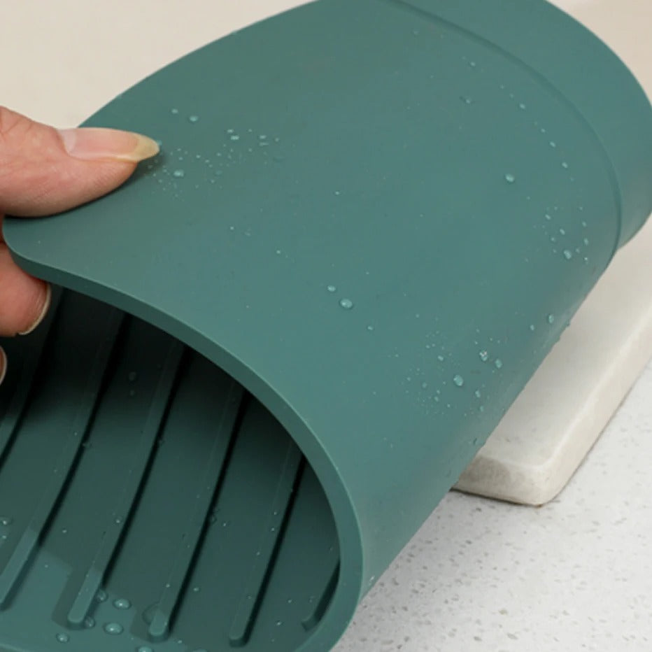 Suporte de silicone verde com gotas de água, indicado para utensílios quentes na cozinha