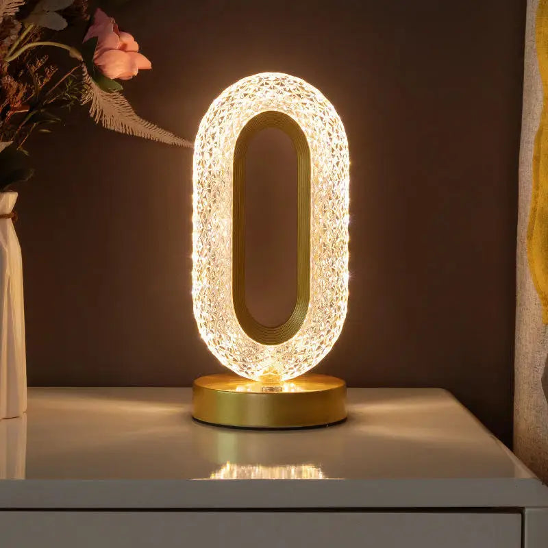 Luminária de mesa oval dourada com luz quente, decorando quarto com vaso de flores