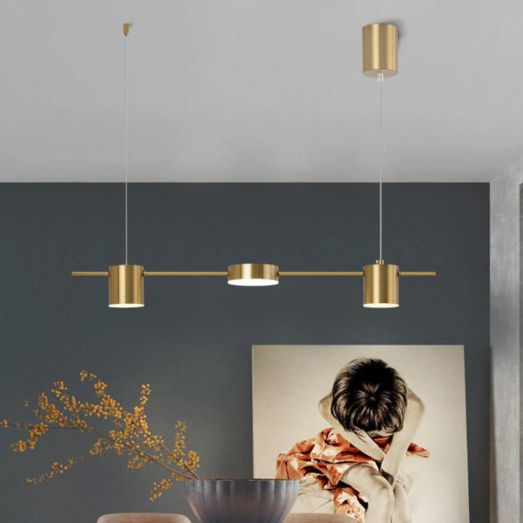 Luminária pendente dourada moderna em ambiente interno com decoração minimalista e quadro de criança triste