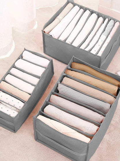 Organizadores cinza de roupas com divisórias, organizando roupas em tons neutros
