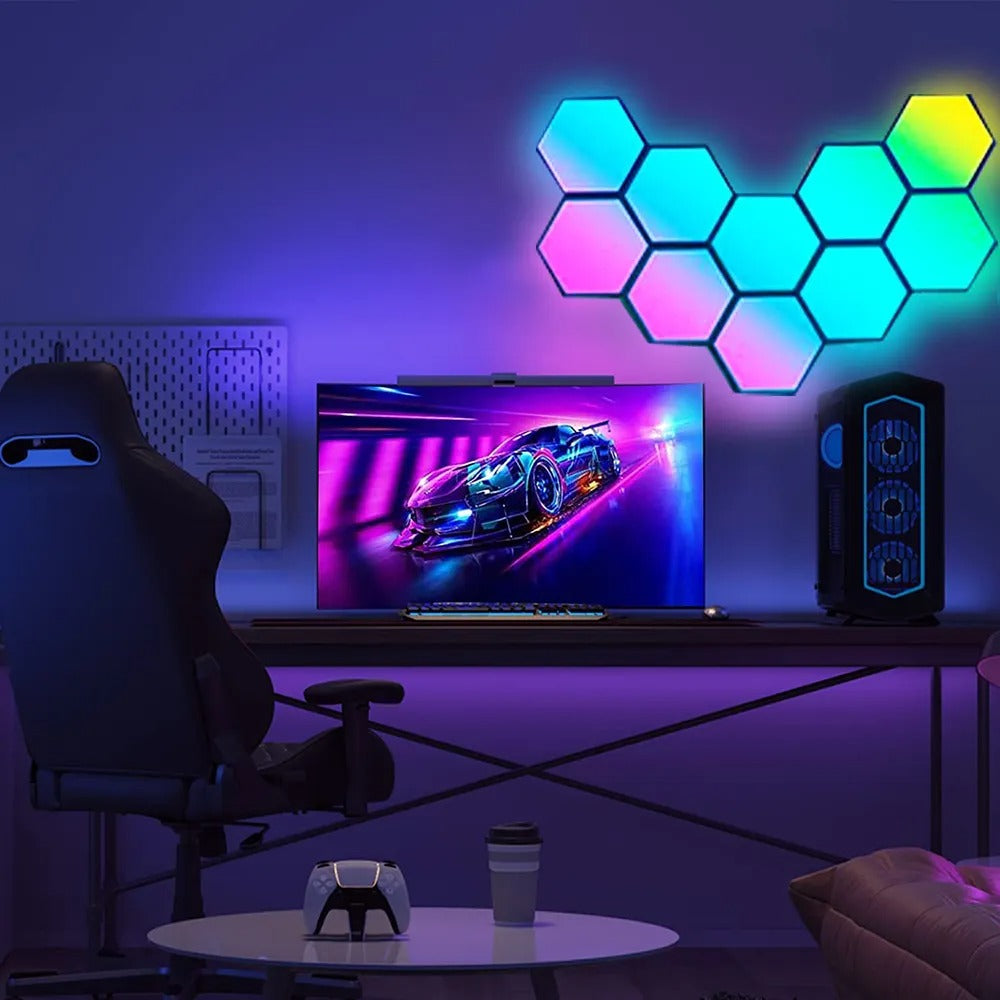 Setup gamer com cadeira, monitor exibindo jogo de corrida, painel de luzes hexagonais coloridas e computador