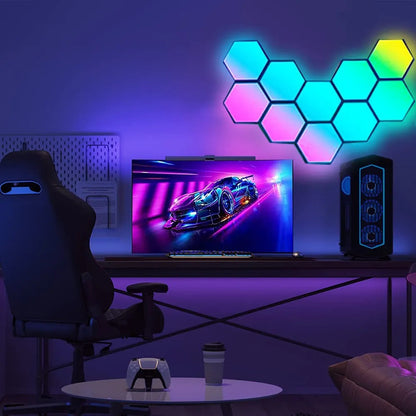Setup gamer com cadeira, monitor exibindo jogo de corrida, painel de luzes hexagonais coloridas e computador