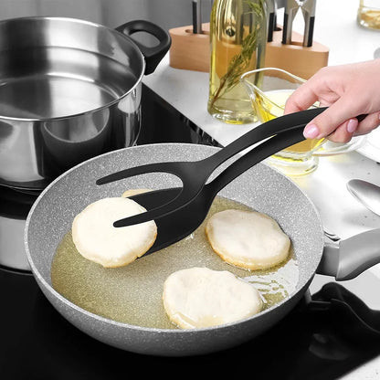 Mão segurando pegador preto virando bolinhos fritando em frigideira cinza na cozinha moderna